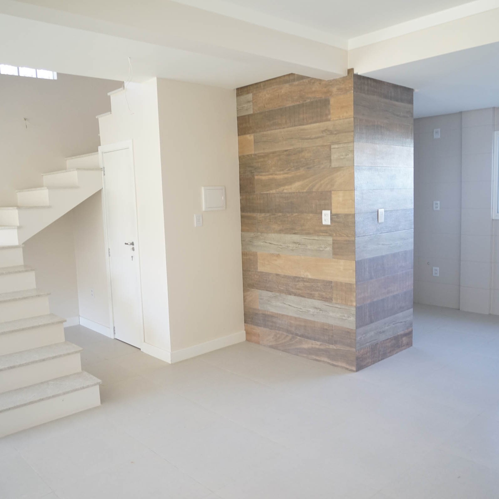 Andar térreo com sala de estar, jantar e cozinha com churrasqueira integrados.