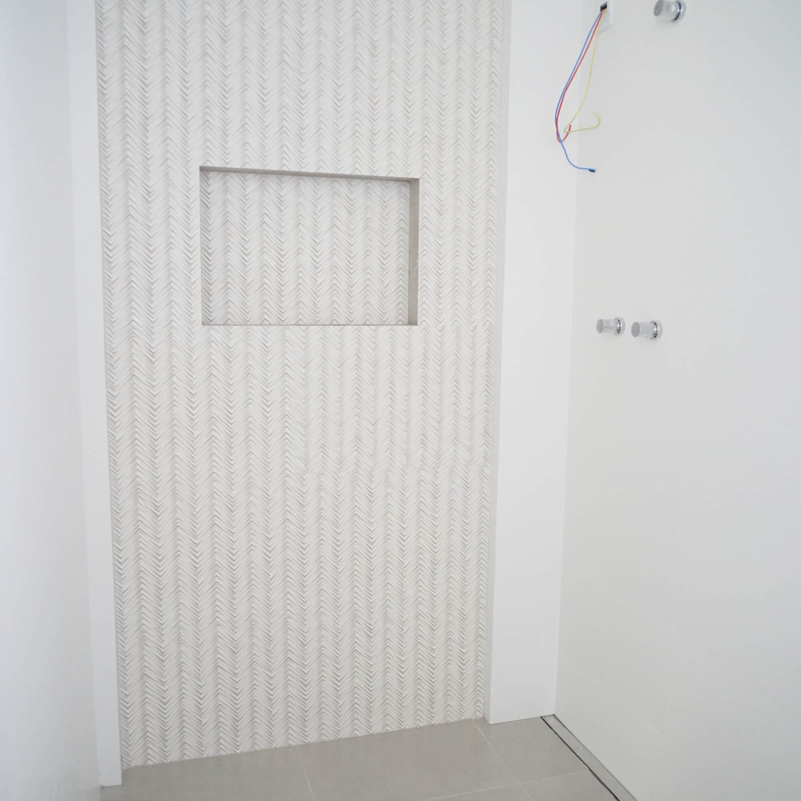 Área generosa para box. Ralo linear e nicho embutido na parede.